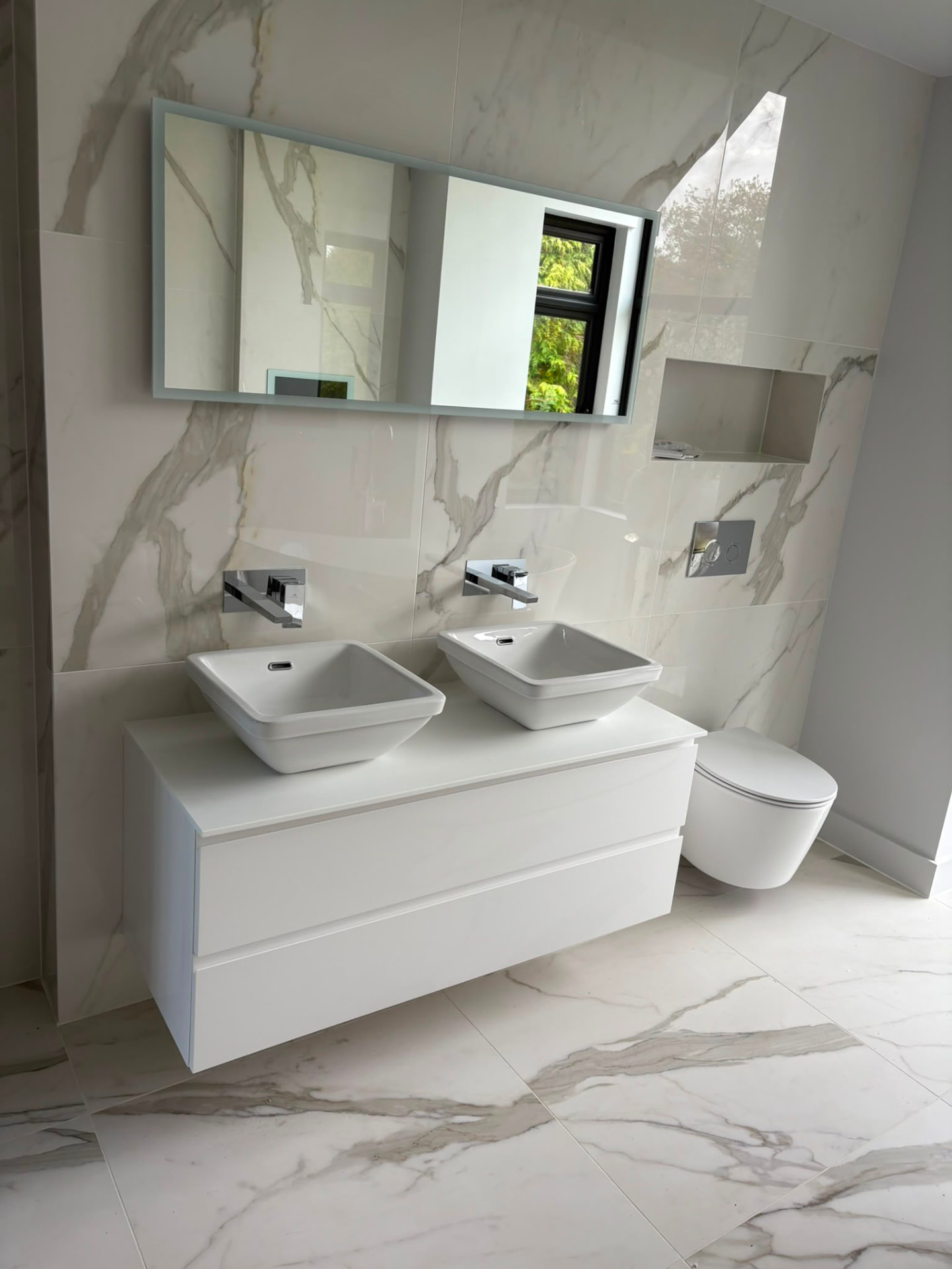 Double vanity unit with twin counter top basins, wall mounted taps and wall hung WC